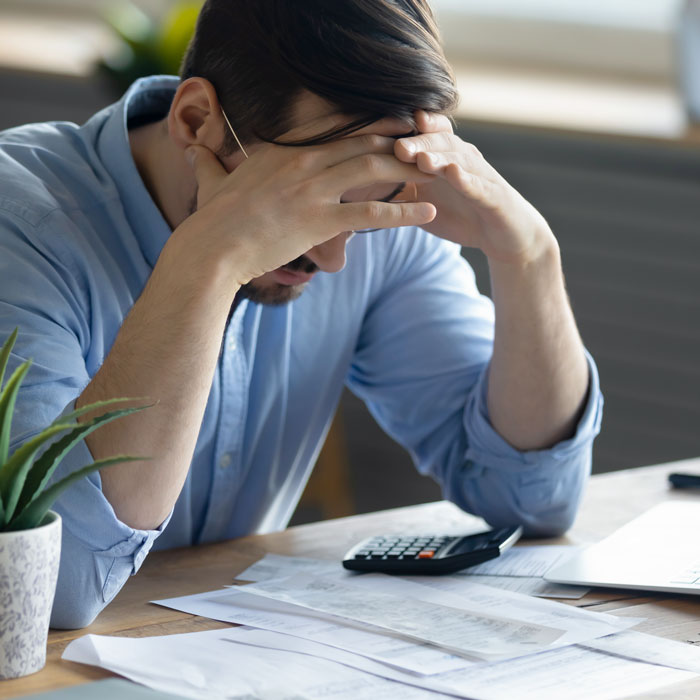 Person reviewing paperwork and finances, showing the administrative pressure of running a cleaning business.